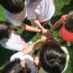 Bambini in cerchio su un prato che uniscono le mani